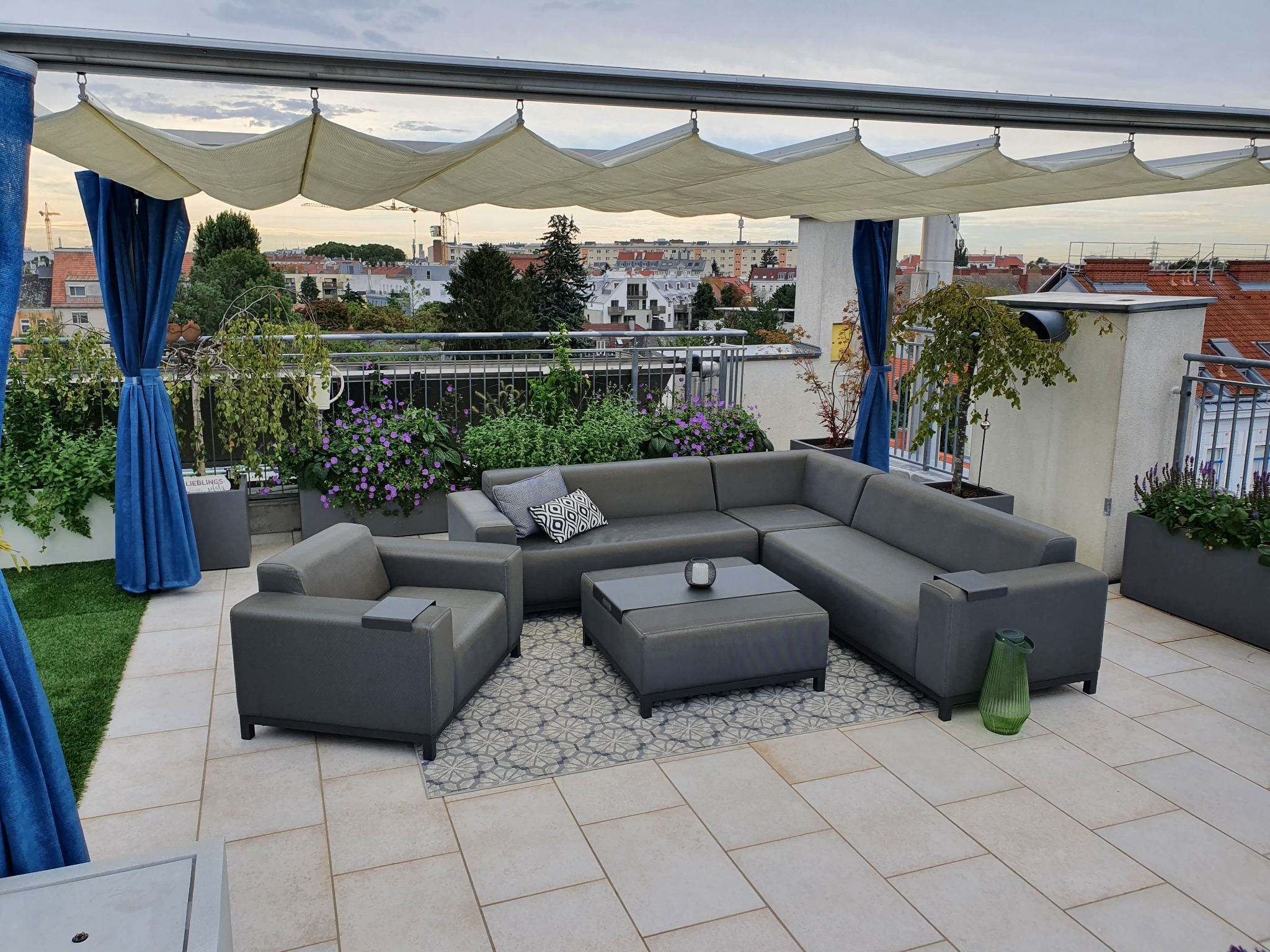 Dachterrassengestaltung in Wien von Pflanzplan mit großzügiger Lounge, Natursteinplatten und begrünten Pflanztrögen